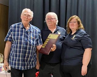 Lion Dave Hansen presents the award to Bob and Christine Teal.